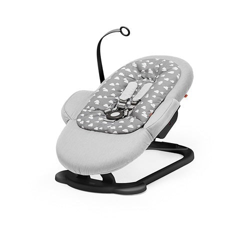 Gray baby bouncer with white cloud pattern and adjustable safety harness.