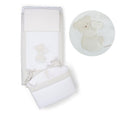 Cream-colored baby crib bedding set featuring embroidered teddy bear holding a heart. 
