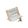 Wooden high chair with light gray pinstriped seat cushion and back support. 
