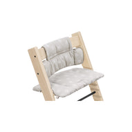 Wooden high chair with grey star-patterned seat cushion and back support for comfortable infant feeding. 
