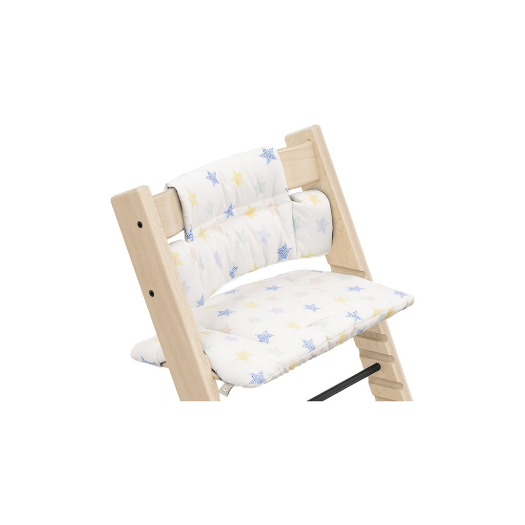 Wooden high chair featuring a removable cushion with a colorful star pattern. 
