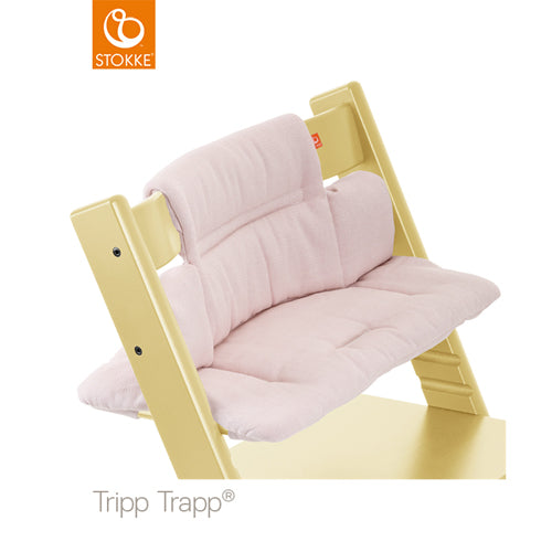 A pale pink Stokke Tripp Trapp high chair cushion set provides plush comfort for babies and toddlers. 
