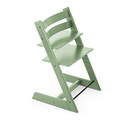 Sage green adjustable wooden high chair, shown from an angle. 
