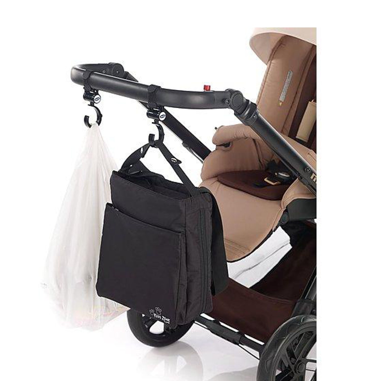 Black stroller organizer with multiple compartments hangs from stroller handlebar, holding a shopping bag and ready for outings. 
